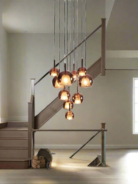 A modern stairwell featuring the Tatva Lights Amber Glow Cluster Chandelier with warm amber glass domes, perfect for luxury interiors and contemporary stairway lighting décor.