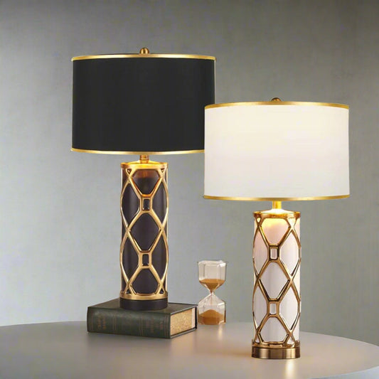 Tatva Lights Artisan Gold Ceramic Table Lamps in black and white variants, featuring elegant gold lattice detailing and drum shades, placed on a marble tabletop for luxurious living room or bedroom décor.