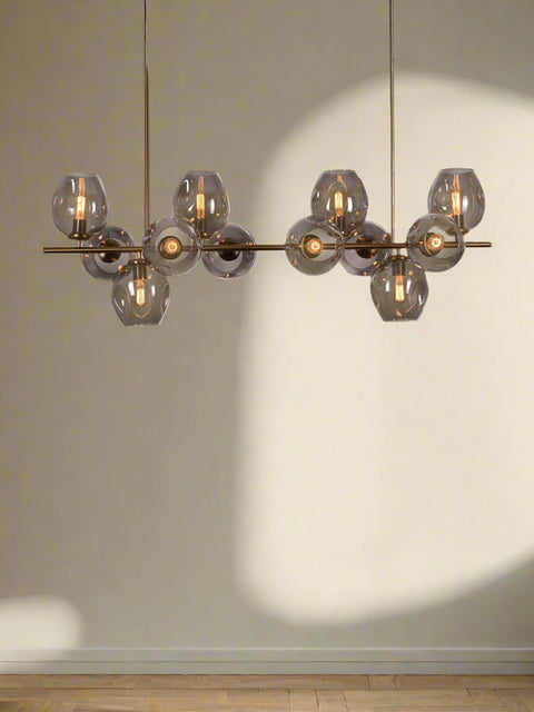 Tatva Lights Caelus Grey Glass Chandelier featuring a cluster of smokey grey glass orbs with a matte black or gold metal frame and integrated LED lighting—ideal for modern living rooms, dining spaces, or contemporary lounges seeking a refined, ambient glow.