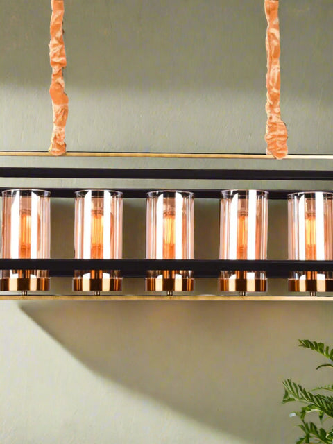 Modern Tatva VaultLine industrial-style chandelier with 6 cylindrical amber glass shades and matte black metal frame, ideal for dining rooms, lofts, and kitchen islands