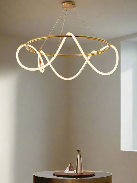 Tatva Lights modern gold loop chandelier with flowing LED light design, suspended from ceiling for luxurious ambient lighting in contemporary interiors.