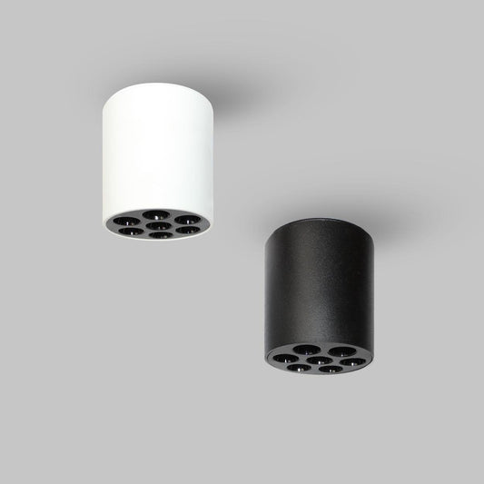 Tatva Lights Elegance Surface LED Downlight shown in black and white cylindrical designs, featuring a sleek, modern form with six recessed LED lights. Ideal for surface mounting on ceilings, the downlights provide focused, ambient illumination for contemporary interiors.