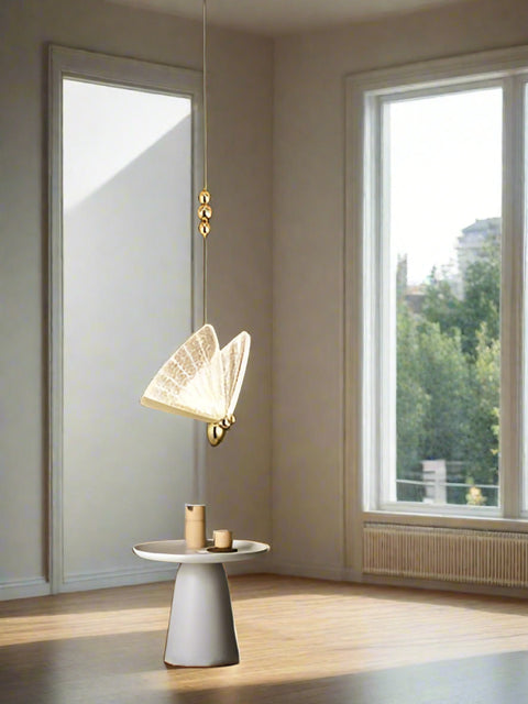 Tatva Lights Gilded Wing Pendant Light with sculptural gold-finished metal wings and soft ambient LED glow, ideal for modern dining spaces, foyers, or luxury interiors