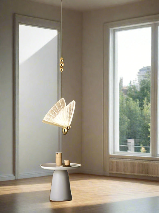 Tatva Lights Gilded Wing Pendant Light with sculptural gold-finished metal wings and soft ambient LED glow, ideal for modern dining spaces, foyers, or luxury interiors