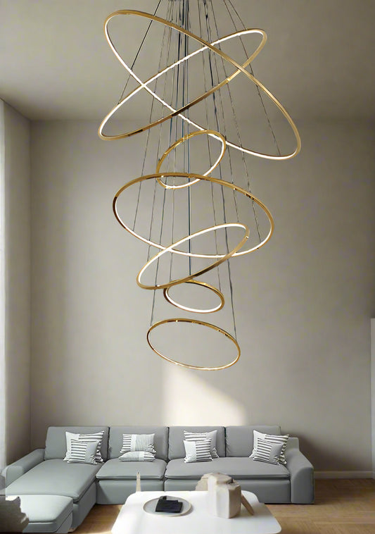 **Alt Text:**
Tatva Lights Gold LED Chandelier featuring a sleek circular design with integrated warm LED lighting, ideal for adding a touch of elegance to dining areas, living rooms, or modern interiors.