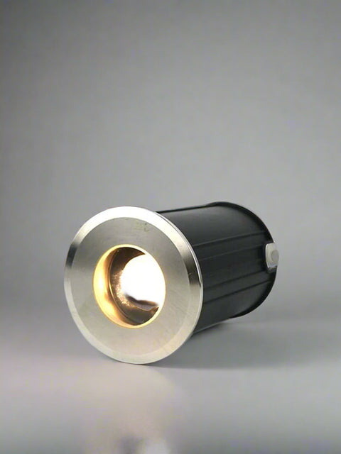 Tatva Lights LUXE PETAL in-ground burial light with circular stainless steel trim – compact outdoor uplighter for highlighting columns, walls, driveways, and architectural landscape features.