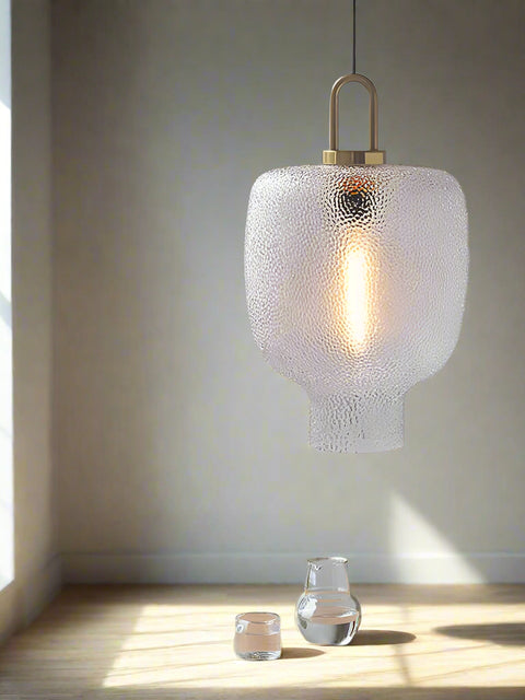 Tatva Lights Modern pendant light with textured glass shade and warm filament glow, featuring a sculptural pebble-inspired form and matte gold accents — ideal for contemporary living rooms, dining areas, and reading corners.