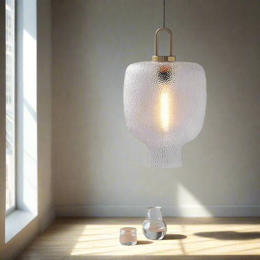 Tatva Lights Modern pendant light with textured glass shade and warm filament glow, featuring a sculptural pebble-inspired form and matte gold accents — ideal for contemporary living rooms, dining areas, and reading corners.