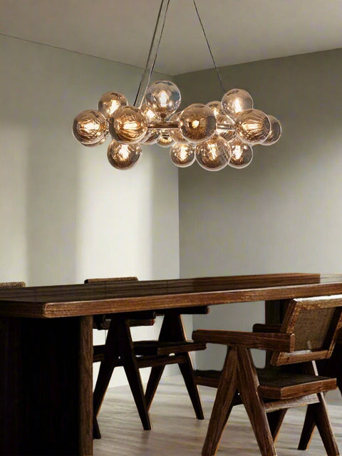 Tatva Lights Lumin Bloom Chandelier – a modern chandelier featuring an arrangement of amber-toned glass globes in a blooming cluster design, ideal for elevating contemporary dining or living spaces.