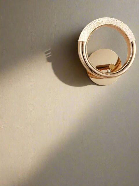 atva Lights rose gold circular LED wall sconce with a dual-ring design and textured upper finish.