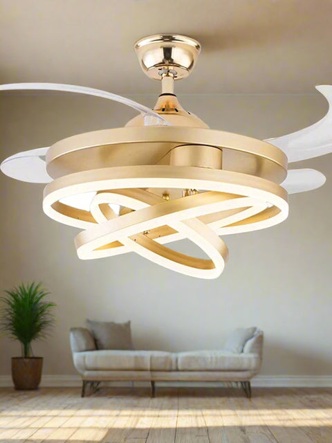 Tatva Lights Modern Gold Ceiling Fan with Retractable Blades and Integrated LED Light. Features a sculptural, intertwined LED ring design and a sleek metallic gold finish, ideal for luxury interiors.