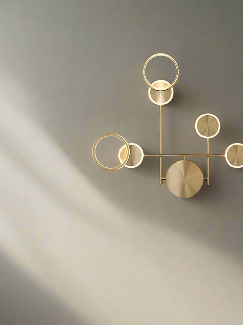 A modern industrial wall sconce with a retro wood glass shade, featuring warm white LED lighting, mounted on a wall in a dark room beside a chair and below a plant.