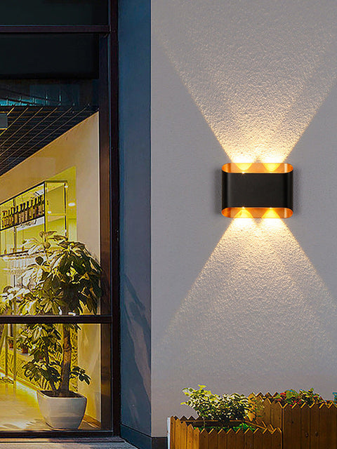 Tatva Lights Noctra Lux Wall Light featuring a sleek, modern silhouette with a matte black and gold finish, offering ambient LED illumination—ideal for contemporary hallways, bedrooms, or living room accent walls.