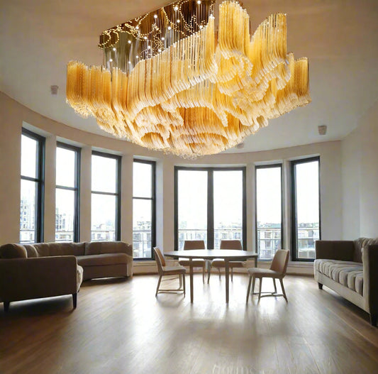 Tatva Lights Optiglo Customised Chandelier – Grand sculptural chandelier with cascading crystal-like elements in golden tones, designed for opulent hotel lobbies, ballrooms, or luxury residences. Tailored elegance with modern craftsmanship for large-scale architectural spaces.