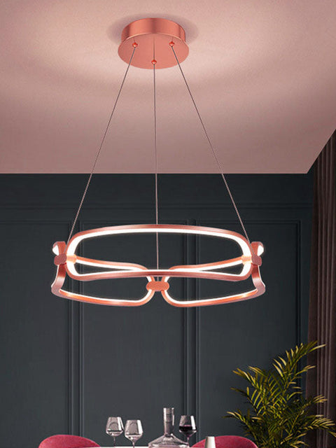 Tatva Lights Oralie Curve Chandelier featuring a gracefully curved metallic frame with integrated LED illumination and a sleek gold finish—perfect for contemporary dining areas, living rooms, or statement ceiling spaces.