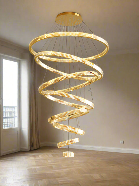 A luxurious rose gold LED chandelier with multiple rings hanging from the ceiling, providing warm white lighting to the room.