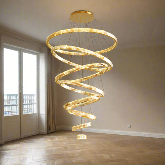 A luxurious rose gold LED chandelier with multiple rings hanging from the ceiling, providing warm white lighting to the room.