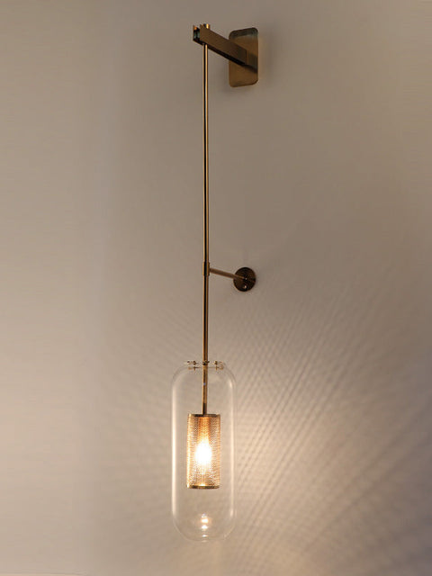 A gold 800 mm long glass wall light with a copper metal mounting, emitting a warm white glow, mounted on a white wall.