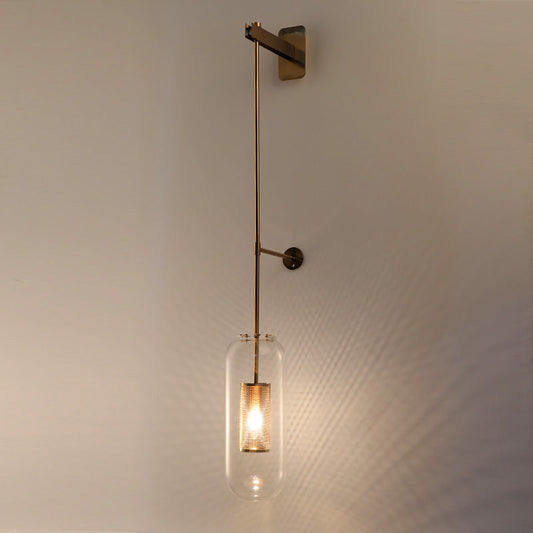 A gold 800 mm long glass wall light with a copper metal mounting, emitting a warm white glow, mounted on a white wall.