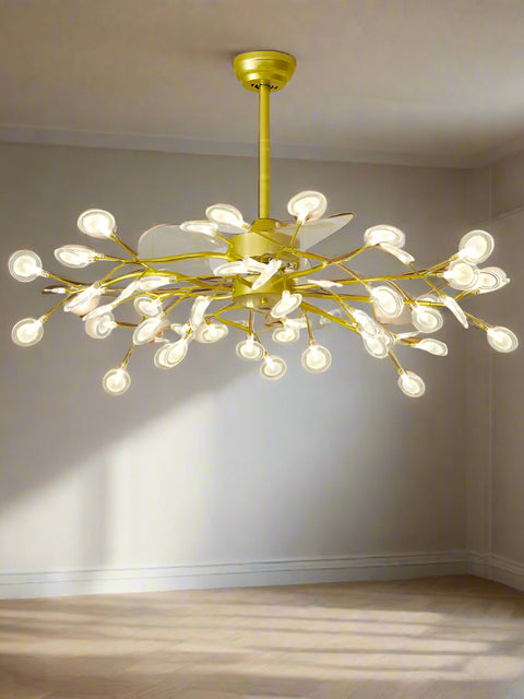 A ceiling-mounted fan chandelier with gold-colored lights and retractable blades, installed in a modern living room setting.