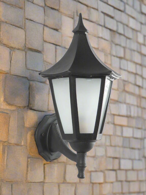 Elegant black outdoor wall lantern with frosted glass panels and vintage design, mounted on a textured white wall — perfect for balconies, patios, and garden entrances by Tatva Lights.