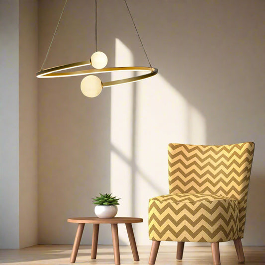 Tatva Lights “Vita” Gold Metal & Glass Hanging Light with dual opal glass globes suspended in a modern ring design.
Perfect for contemporary living rooms, dining areas, or high ceilings seeking artistic lighting.
Crafted with a matte gold finish and ambient LED glow for a luxurious, sculptural statement.