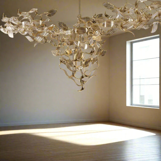 Tatva Lights Wove Custom Glass Chandelier – handcrafted designer chandelier with interwoven glass design and premium metallic finish. Ideal for modern living rooms, dining areas, and luxury interiors. Adds ambient lighting and elegant décor appeal to any space.