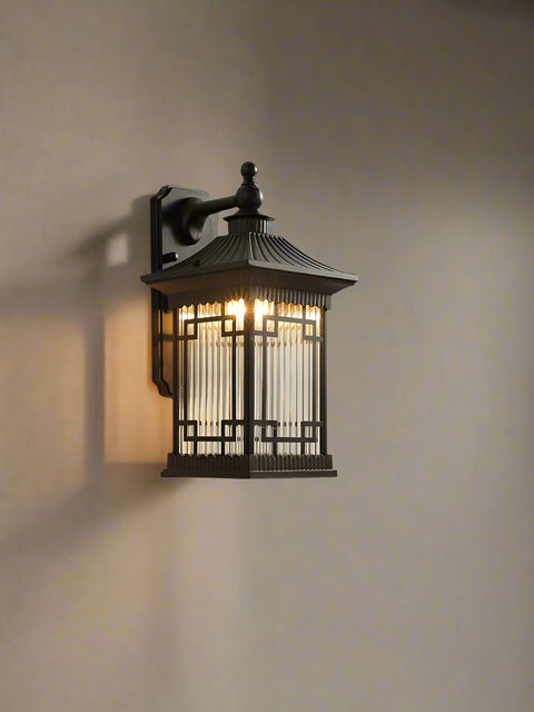 Tatva Lights Zenshiro Outdoor Wall Lantern – An Asian-inspired black metal wall light featuring a pagoda-style roof and intricate geometric frame, ideal for adding ambient glow and traditional elegance to exterior walls and entryways.
