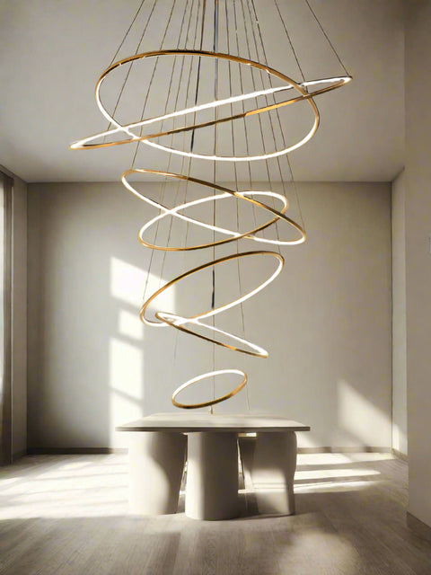 Tatva Lights Éclaire Cascade Gold Chandelier featuring cascading tiers of crystal-like elements and a polished gold finish, with integrated LED lighting—ideal for luxurious staircases, grand entryways, or upscale living spaces.