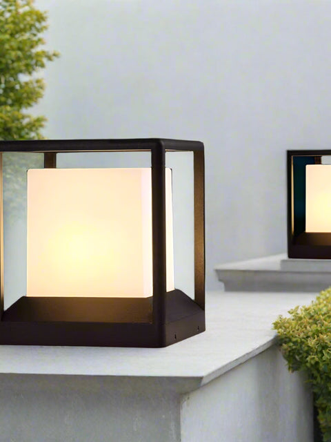 Tatva Lights modern outdoor cube pillar lights with frosted glass center and black metal frame, elegantly illuminating a garden pathway with warm ambient lights