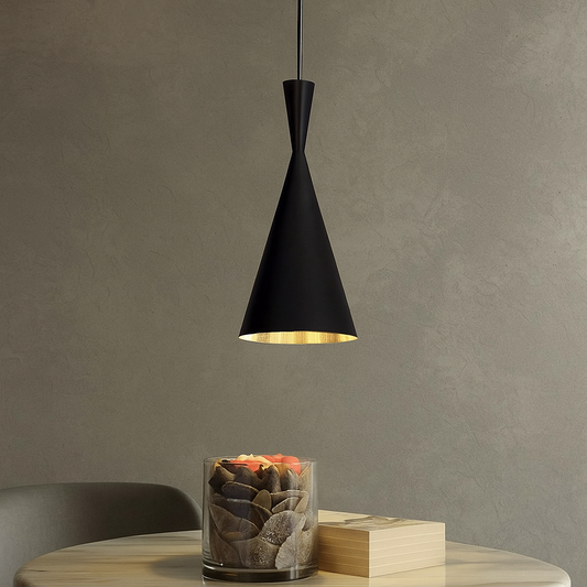 Modern black cone pendant light hanging above a minimalist table with decorative stones and a book, ideal for contemporary interior lighting design.