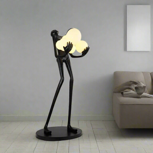 Modern black sculptural floor lamp holding glowing cloud-shaped lights – luxury artistic lighting for contemporary home interiors by Tatva Lights.