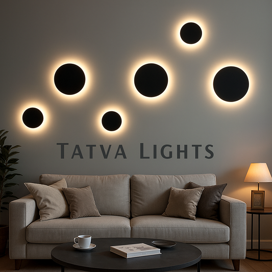 Tatva Lights LumoHalo Wall Lights – Eclipse Series: A modern living room featuring circular wall-mounted LED lights with black centers and glowing white halos, arranged in an abstract pattern above a beige sofa