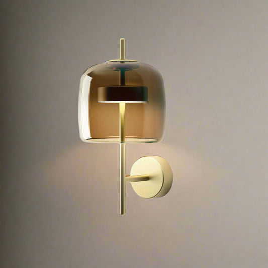 A modern amber glass wall sconce with a brushed gold metal frame, perfect for ambient lighting in living rooms, bedrooms, or hallways – Tatva AuraGlow designer wall light