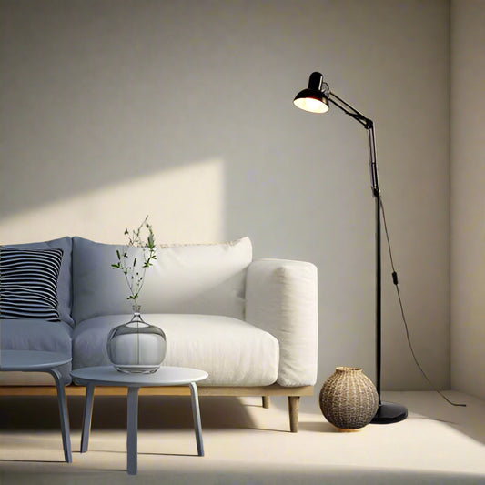 Tatva Lights Adjustable Swing Arm Floor Lamp – A sleek black metal floor lamp with a dome-shaped shade and movable swing arm, placed beside a minimalist white sofa. Perfect for modern interiors, reading nooks, or ambient task lighting.