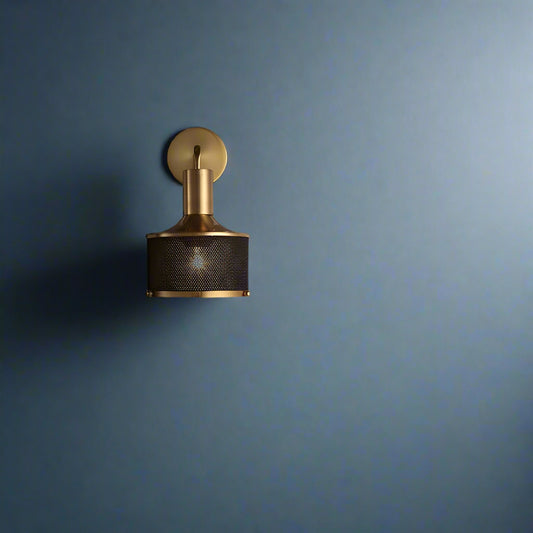 Tatva Lights AMBER GLOW Wall Sconce – a modern industrial wall light with a sleek gold-finished metal arm and black perforated mesh shade, radiating warm ambient lighting. Ideal for contemporary living rooms, hallways, bedrooms, or feature walls, offering a perfect blend of style and sophistication.