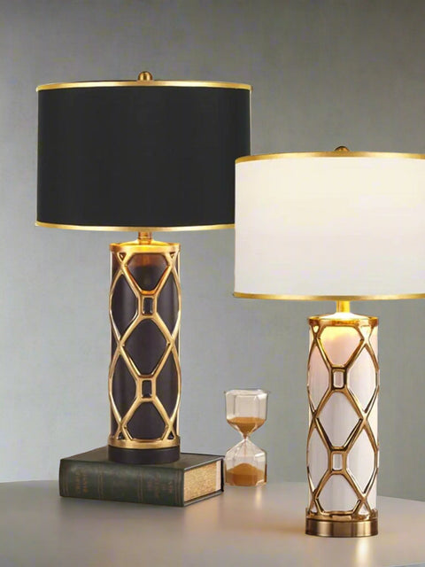 Tatva Lights Artisan Gold Ceramic Table Lamps in black and white variants, featuring elegant gold lattice detailing and drum shades, placed on a marble tabletop for luxurious living room or bedroom décor.