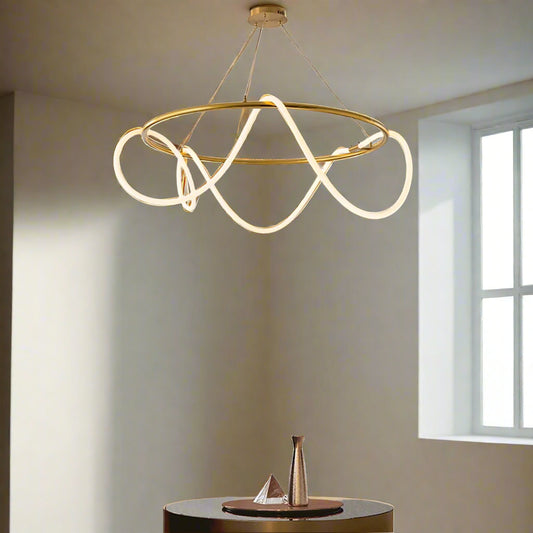Tatva Lights modern gold loop chandelier with flowing LED light design, suspended from ceiling for luxurious ambient lighting in contemporary interiors.