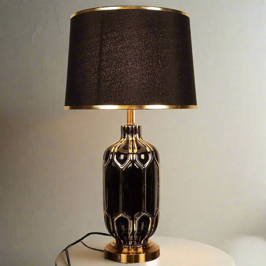Tatva Lights Gold-Embroidered Ceramic Table Lamp featuring a glossy black ceramic base with intricate gold detailing, paired with a matching black lampshade trimmed in gold—an opulent lighting piece that brings sophistication and drama to any space.