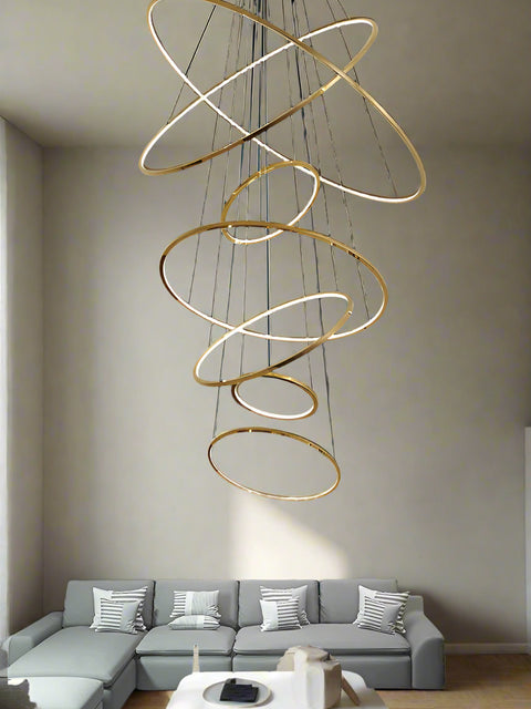 **Alt Text:**
Tatva Lights Gold LED Chandelier featuring a sleek circular design with integrated warm LED lighting, ideal for adding a touch of elegance to dining areas, living rooms, or modern interiors.
