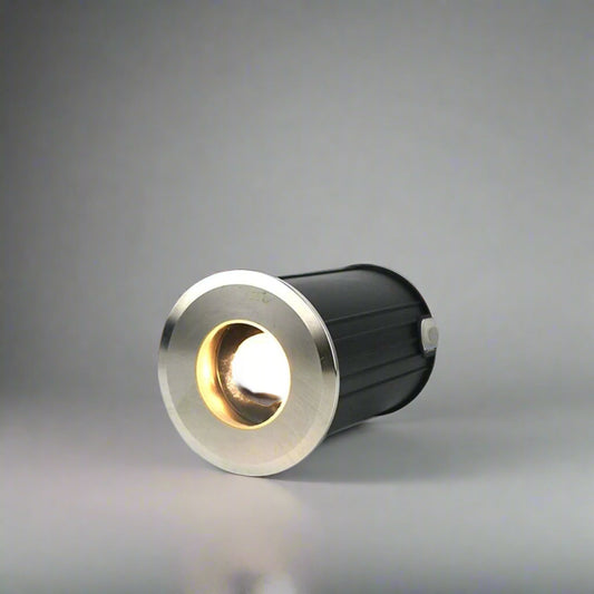 Tatva Lights LUXE PETAL in-ground burial light with circular stainless steel trim – compact outdoor uplighter for highlighting columns, walls, driveways, and architectural landscape features.