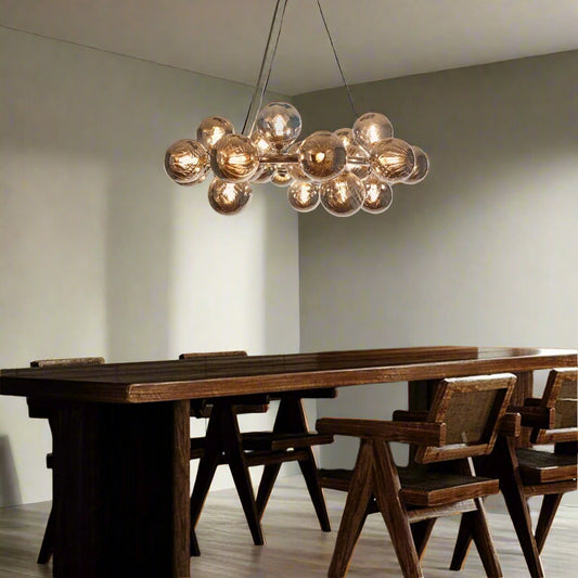 Tatva Lights Lumin Bloom Chandelier – a modern chandelier featuring an arrangement of amber-toned glass globes in a blooming cluster design, ideal for elevating contemporary dining or living spaces.