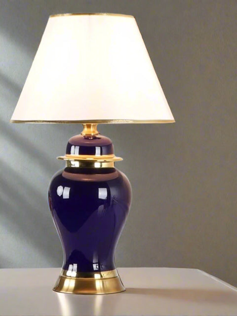 Tatva Lights Multi Color Ceramic Table Lamp featuring a rich deep blue ceramic base with elegant gold accents, paired with a classic white lampshade trimmed in gold—perfect for adding a touch of sophistication and color contrast to any décor.