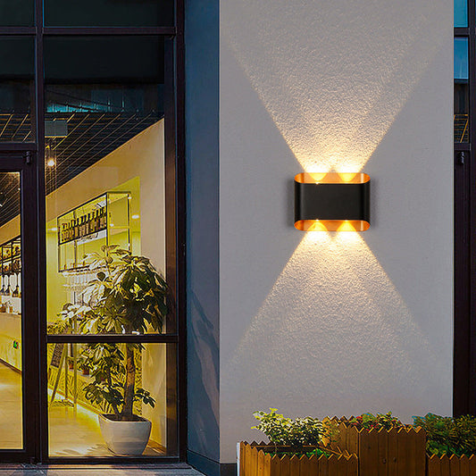 Tatva Lights Noctra Lux Wall Light featuring a sleek, modern silhouette with a matte black and gold finish, offering ambient LED illumination—ideal for contemporary hallways, bedrooms, or living room accent walls.