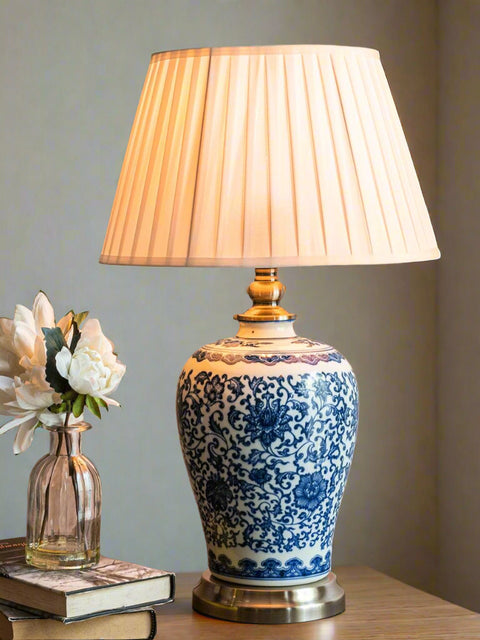 Tatva Lights vintage-style ceramic table lamp with intricate blue floral patterns and a pleated beige lampshade — ideal for classic home interiors, bedside tables, or reading nooks.