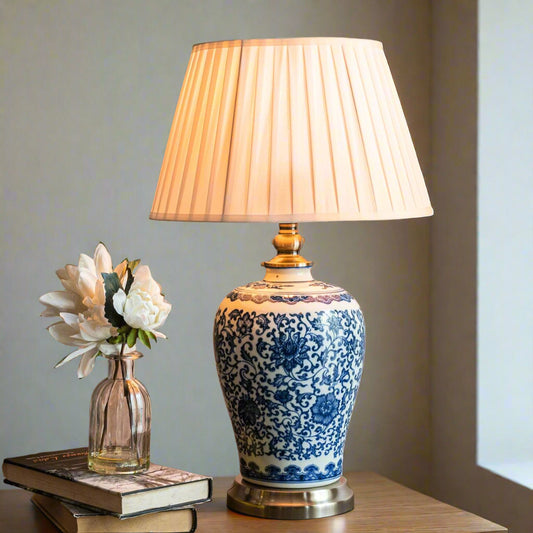 Tatva Lights vintage-style ceramic table lamp with intricate blue floral patterns and a pleated beige lampshade — ideal for classic home interiors, bedside tables, or reading nooks.